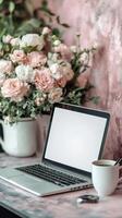 Cozy workspace with laptop, fresh flowers, and coffee in a pink-toned setting photo