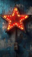 Bright red star marquee light illuminating a rustic blue wall in an urban setting at night photo