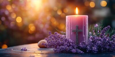 Purple candle with cross surrounded by lavender flowers and warm light in the background during a serene evening setting photo
