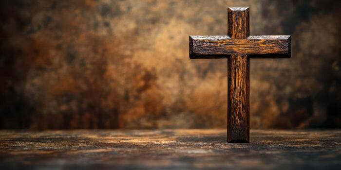 Wooden cross rests on a textured surface with a warm, blurred background, creating a reflective atmosphere for contemplation photo