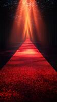 Dramatic red carpet pathway illuminated by stage lights in a dark forest setting during an evening event photo