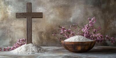 Cross and bowl of salt with flowers on weathered surface during serene setting photo