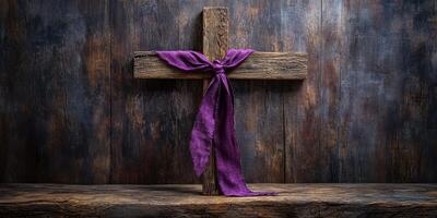 Wooden cross adorned with purple cloth on rustic wooden surface in a serene setting photo