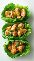 Freshly prepared chicken lettuce wraps garnished with chopped green onions on a clean white background photo