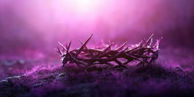 Crown of thorns resting on a purple-lit ground surrounded by soft grass and misty atmosphere photo