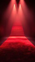 Bright red lights illuminate a staircase leading up from a red carpet in a dark venue photo