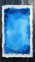 Blue watercolor art piece on textured paper background with wooden surface photo