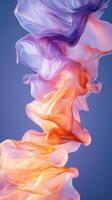 Colorful fabric flows gracefully in striking shades of orange, purple, and blue against a soft gradient backdrop photo