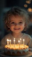 Child celebrates a birthday with joy while holding a cake adorned with candles in a softly lit room photo