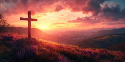 Cross on a hillside at sunset with vibrant colors illuminating the landscape photo
