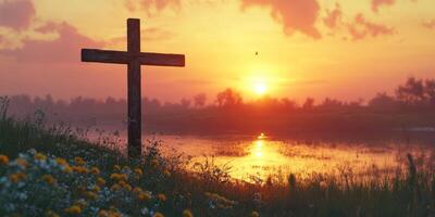 Sunset over a peaceful lake with a wooden cross and colorful flowers in the foreground photo