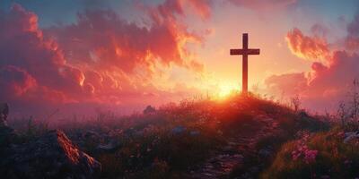 Sunset over a hill with a wooden cross surrounded by flowers and grass photo