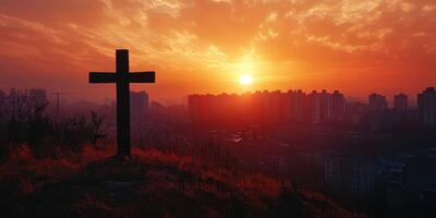 Beautiful sunset over a city skyline with a cross silhouette in the foreground photo
