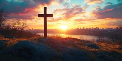 Sunset view with a cross silhouette over city skyline and river in the background photo