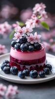 Blueberry dessert topped with blossoms on a pale plate arranged with beautiful spring flowers photo