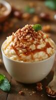 Delicious dessert featuring creamy rice pudding topped with caramel and crushed nuts in a cozy kitchen setting photo