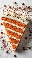 Delicious slice of layered carrot cake with cream icing and chocolate sprinkles on a white plate photo