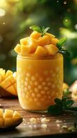 Refreshing mango smoothie topped with fresh fruit and mint leaves in a glass jar on a wooden table photo