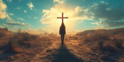 Person standing in a desert landscape at sunset with a large cross in the background photo