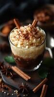 Creamy rice pudding topped with cinnamon and spices served in a glass on a dark wooden surface photo