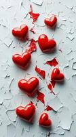 Red hearts scattered on cracked surface creating an artistic expression of love and brokenness photo