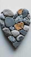 Heart shaped arrangement of pebbles showcasing natural textures and colors against a plain background photo
