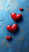 Heart shapes in glossy red against a textured blue background evoke feelings of love and passion photo