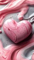 Colorful heart shape surrounded by swirled pink and gray patterns on a smooth surface photo