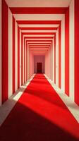 Vibrant red and white striped hallway leads to a doorway with a red carpet illuminating the pathway photo
