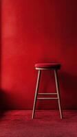 Empty red stool against a bold red wall and carpet in a minimalist interior setting photo