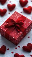 Valentine gift wrapped in red with white hearts surrounded by decorative hearts on a textured background photo