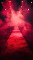 Vibrant red runway with fog prepared for a fashion event at night with dim lights illuminating fabric and seating photo