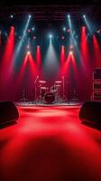 Dramatic red lighting highlights an empty stage with a drum set in preparation for a live music performance photo