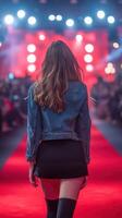 Model walks down the runway at a fashion show during an evening event in a vibrant atmosphere filled with bright lights photo