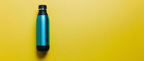 Turquoise Water Bottle On Yellow Background photo
