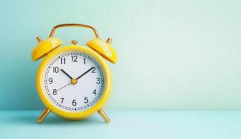 Yellow Alarm Clock Against Blue Background photo