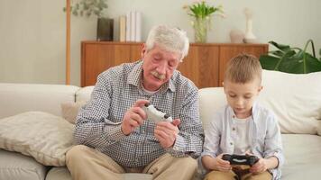 Happy family. Old senior man grandfather boy grandson playing game with joysticks at home. Smiling grandparent and child using gamepads for game. Older generation modern tech usage video