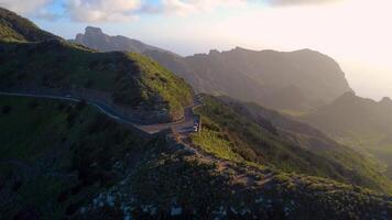 Breathtaking aerial view of Masca Valley from Mirador Altos de Baracan in Tenerife, Canary Islands, showcasing dramatic cliffs, lush greenery, and winding mountain roads under a cloudy sky video