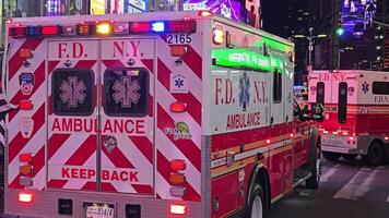 New York. US. 03.02.2025 FDNY ambulances with flashing emergency lights in Times Square, responding to a call amid bright billboards and the vibrant nighttime city atmosphere video