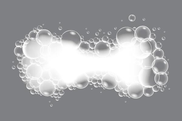 Soap bubbles, displaying unique designs, gracefully float on a plain gray surface
