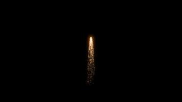 Bright golden spark trail shooting upwards in the dark with glowing particles. Firework effect concept video