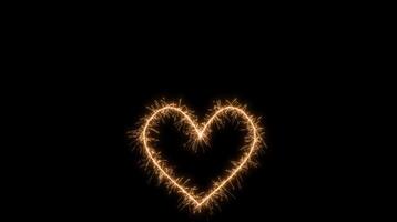 Glowing golden heart shape created with sparklers on a dark background with sparkling light effect. Love concept video