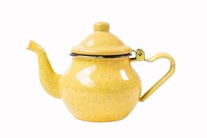 vintage enamel yellow teapot with spotted pattern with curved spout and handle resembling heart shape isolated on white background photo