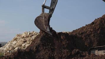 An excavator is efficiently digging and removing soil at a busy construction site. Clip video