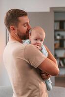 Holding, kid in hands. Father with his newborn baby is indoors. Conception of single dad photo