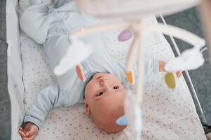 Top view ,of newborn baby that is lying down in the cradle photo