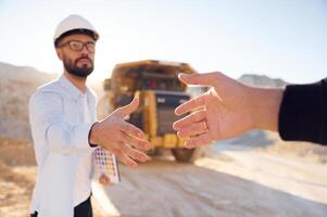 Giving a hand.. Making, a deal. Man in uniform is working in the quarry at daytime photo