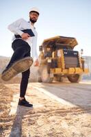 Having fun, making ,a kick by leg. Man in uniform is working in the quarry at daytime photo