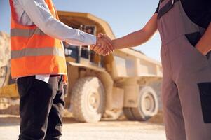 Making ,a deal. Doing handshake. Two men in uniform are working together in the quarry photo