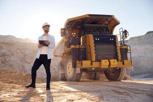 Smart man ,in glasses and ,in uniform is working in the quarry at daytime photo